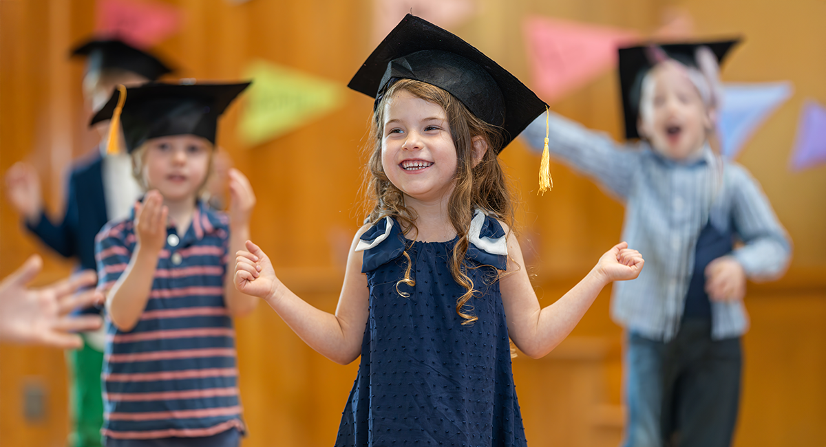 Happy Preschool students in graduation caps